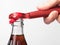 A hand using bottle opener to open the soda