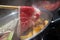 Hand using chopsticks pick premium raw beef sliced beef over the hot pot soup for Shabu Shabu