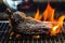 Hand using silver serving kitchen tongs holding raw meat beef steak bbq grilling on rack charcoal stove with smoke and fire flame