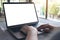 A hand using and touching laptop with blank white desktop screen on table in cafe