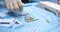 The hand of a veterinary surgeon takes a screw from the table with instruments to install a plate on a broken bone. In