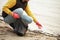 Hand of volunteer lift off litter beach. Spring cleaning in coastline, outdoor trash and rubbish