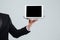 Hand of waiter in black suit holding blank screen tablet