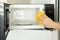 hand washes a microwave oven with a rag from food residues, dirt