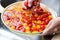 Hand washing cherry tomato with running water in household sink