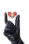 Hand wearing black leather glove holding heart