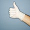 Hand wearing rubber glove giving the thumbs up signal.