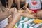 Hand weaving mandalas. A teacher on the beach shows her students how to weave decorative patterns. Creation of special symbols.