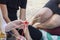 Hand weaving mandalas. A teacher on the beach shows her students how to weave decorative patterns. Creation of special symbols.