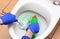 Hand of woman in blue glove cleaning toilet bowl