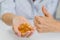 Hand of a woman with fish oil Omega-3 capsules. Shows thumbs up