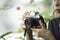 Hand woman holding the camera Taking pictures Background blurry trees