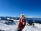Hand of woman holding glass of eggnog against spectacular winter panorama in the Austrian Alps. Vorarlberg, Austria.