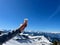 Hand of woman holding glass of eggnog against spectacular winter panorama in the Austrian Alps. Vorarlberg, Austria.