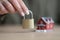 Hand of woman holding iron door lock against model of house