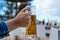 Hand of woman holding a pint of cold beer against blurred beach