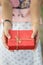 hand of a woman holding a red gift box in concept of a special d
