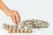 Hand of woman putting coin to rising stack of coins, Saving money concept.