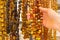 Hand of woman with shiny womanly amber necklaces on stall at the bazaar