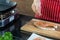 Hand of woman is sprinkled with pepper and rosemary on a piece of salmon cooking delicious salmon steak at kitchen