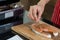 Hand of woman is sprinkled with pepper and rosemary on a piece of salmon cooking delicious salmon steak at kitchen