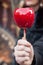 Hand of woman with sweet candy red apple at the chri