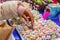 Hand of a woman taking one of the Calaveritas of sugar glass and sequin, typical sweets during the time of the day of the dead in