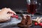 Hand of woman taking piece of christmas chocolate sponge cake with sugar powder