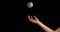 Hand of Woman Throwing a Ball of Baseball against Black Background