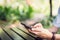 Hand of woman using smartphone on wooden table and typing message to his friends.