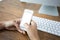 Hand woman using a telephone, empty screen smart phone and computer on wooden table In home office. with clipping path