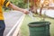 The hand of a woman who is dumping garbage in the trash.