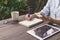 Hand woman write notebook and holding phone on wood table with c