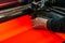 Hand of worker adjusts the flying head of the laser cutting machine