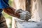 hand of worker plastering cement at the wall for building house