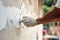 hand of worker plastering cement at the wall for building house