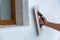 Hand of a worker with a tool for sanding and making smooth and even the surface of a house wall insulated with styrofoam