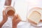 Hand of  working woman holding  cup coffee On the white table background, on the table there was bread note book and smart phone