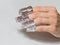 Hand with wrapped fingers in foil. Manicurist wrapping finger nails with foil during the procedure of manicure at a Spa salon