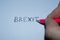 Hand writes in pencil the word `Brexit` on white paper