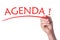 Hand writes word agenda with red marker