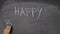 Hand writing `HAPPY BIRTHDAY` on black chalkboard