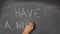 Hand writing `HAVE A NICE DAY` on black chalkboard