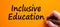 Hand writing \'inclusive education\'   on orange background. Business  inclusion and inclusive