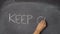 Hand writing `KEEP CALM` on black chalkboard