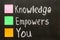 Hand writing Knowledge Empowers You on blackboard.