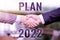 Hand writing sign Plan 2022. Business overview detailed proposal doing achieving something next year Two Professional