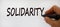 Hand writing `solidarity`, isolated on beautiful white background. Concept
