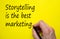 Hand writing `storytelling is the best marketing`, isolated on yellow background. Business concept