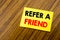 Hand writing text caption inspiration showing Refer A Friend. Business concept for Referral Marketing written on sticky note paper